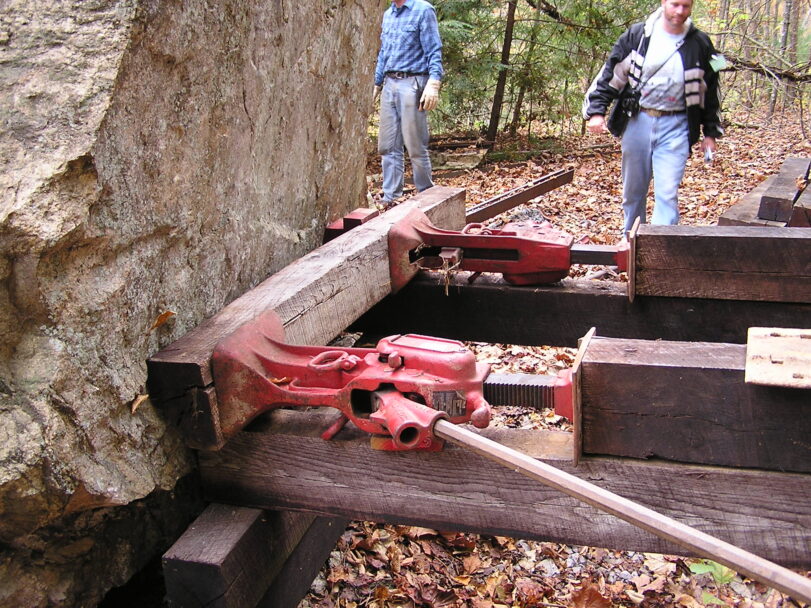 rail jacks against fallen rock boulder
