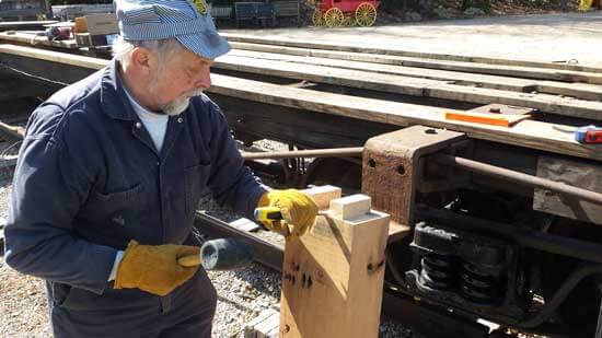 worker chiseling wood beam