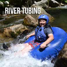 boy tubing in river rapids