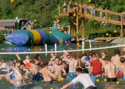 kids in lake playing a ball toss game with large inflatable blob in background