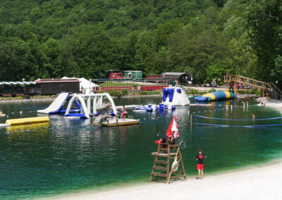 lake with floating inflatables and beach