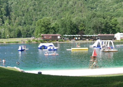 lake with floating inflatables and beach