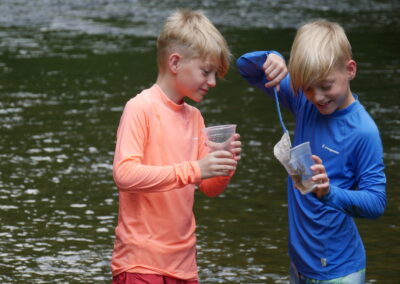 2 boys with river critters