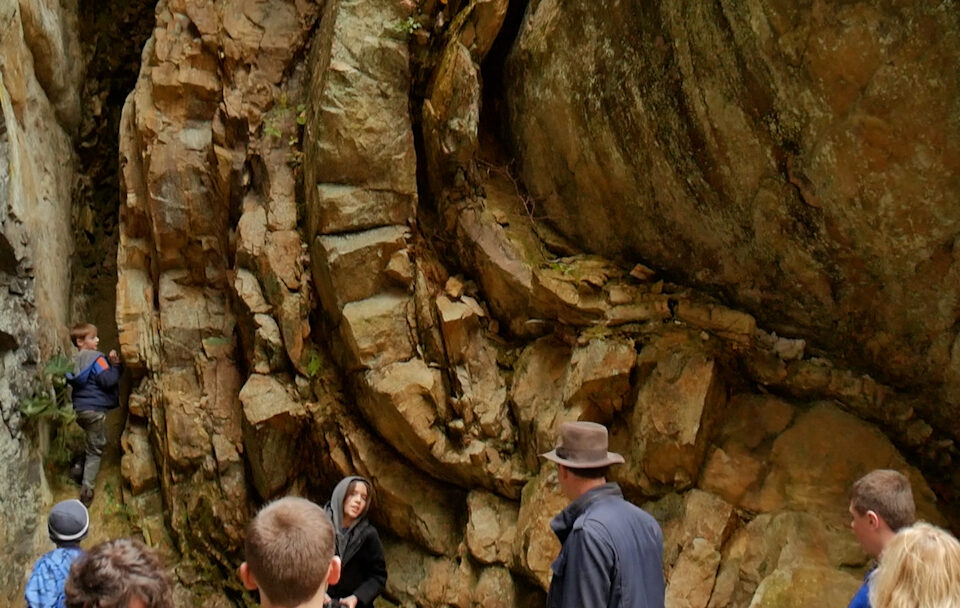 people observing curved rock layers