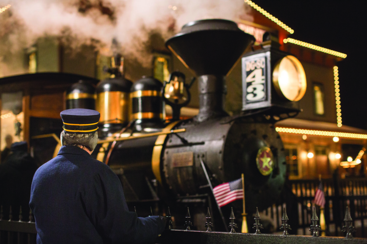 conductor and steam locomotive at night