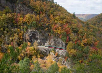 train at retaining wall - fall mountain backdrop